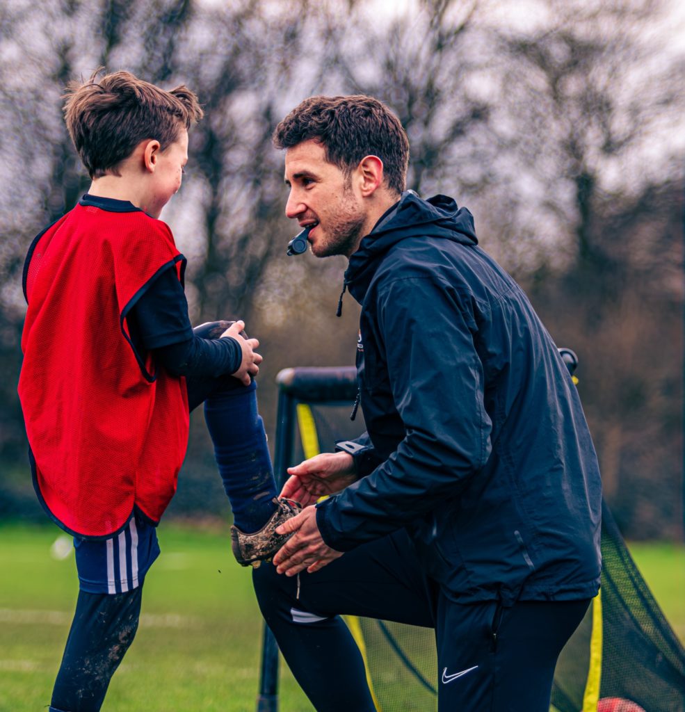 Football Coach talking to boy