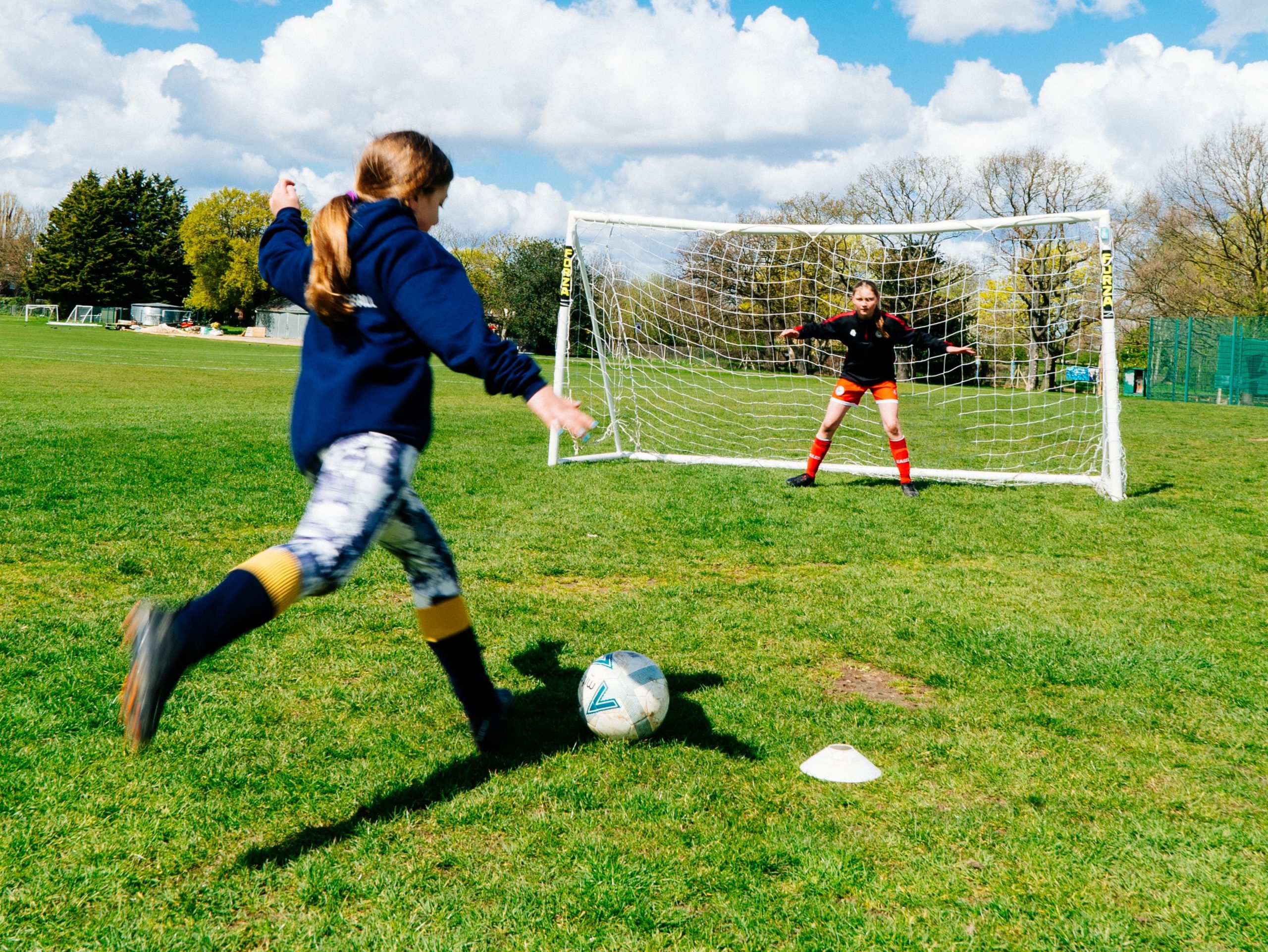 Girl kicking football